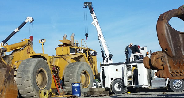 repairs and crane inspections being done on crane truck by service mechanics technicians